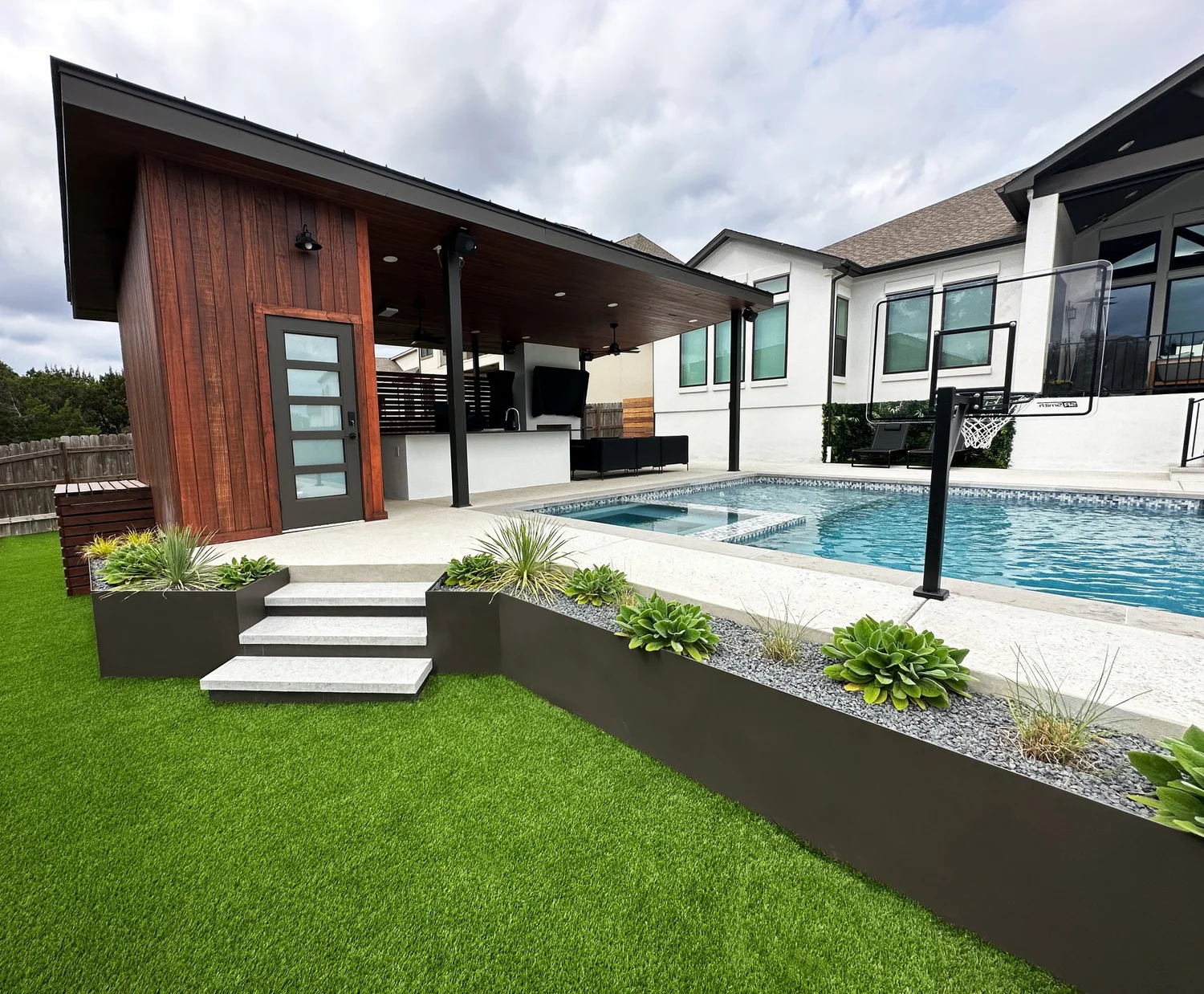 Turf and stone steps leading to a pool