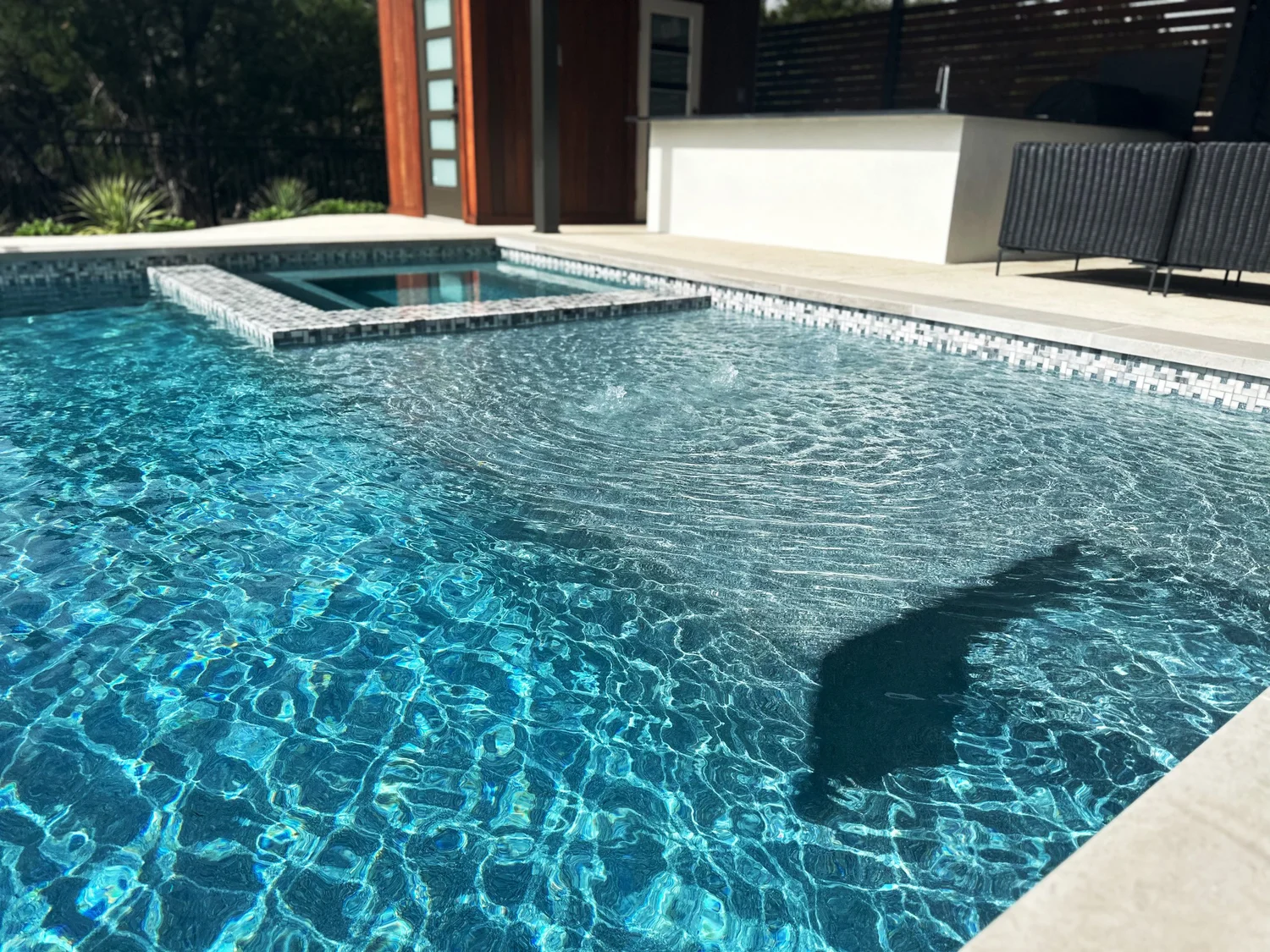 A finished Pool Sharp build in the Texas Hill Country — clean coping, turf, and a deep blue finish at golden hour.